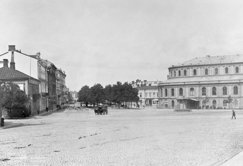 Näkymä Erottajankadulta pohjoisen suuntaan. Oikealla on vuonna 1866 käyttöön vihitty Svenska Teaternin rakennus (Ruotsalainen teatteri) ja teatterin edessä on Erottajan kaivo. Kuva: Helsingin kaupunginmuseo / Daniel Nyblin. Kuvausaika: 1890.